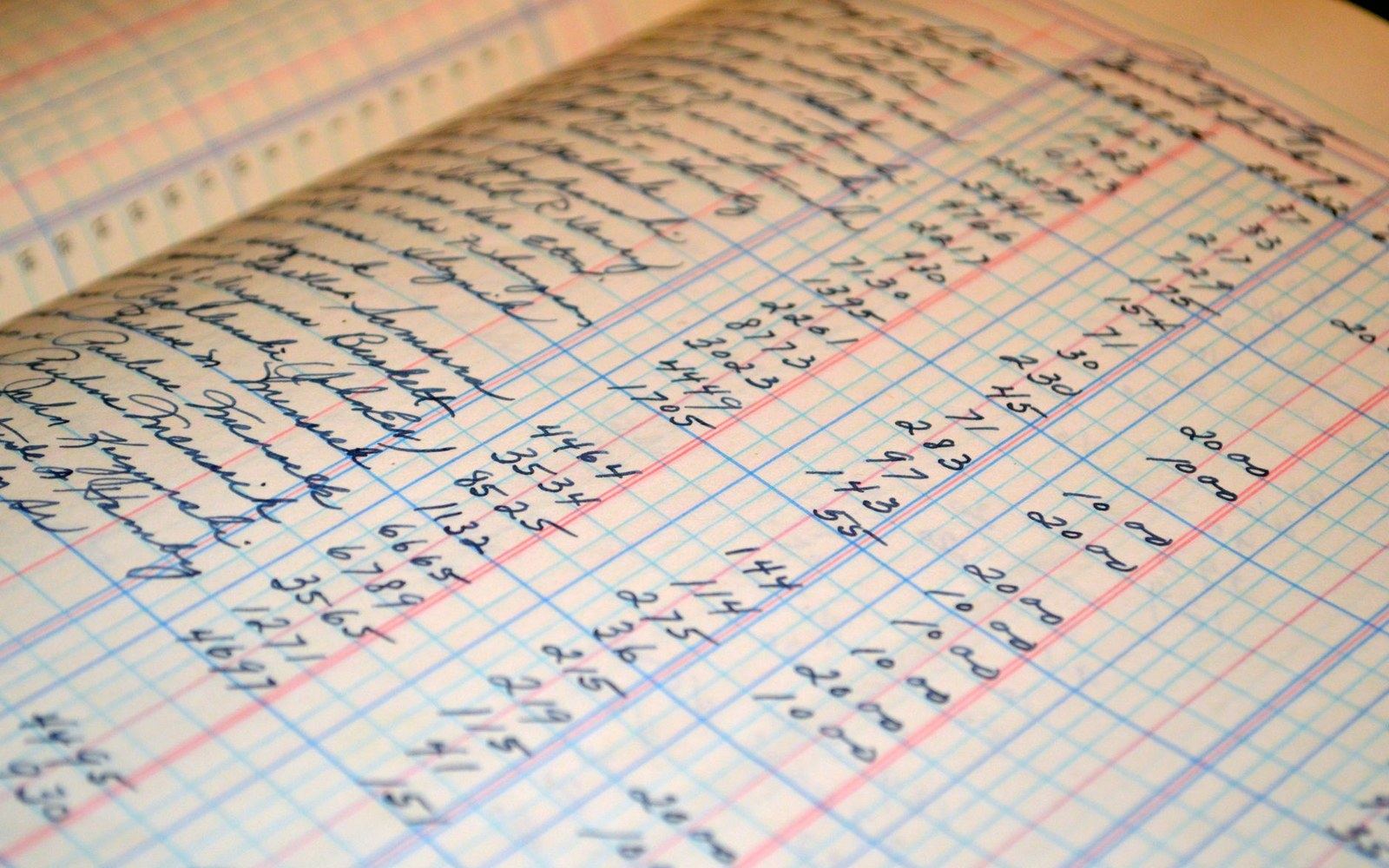 Handwritten ledger pages filled with columns of numbers in ruled accounting book
