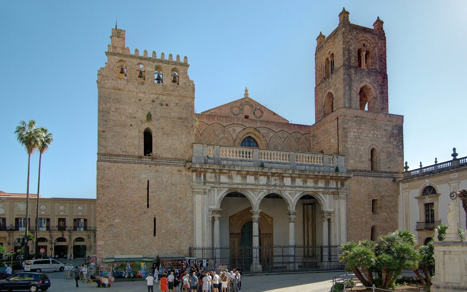 Twin bell towers flank the arched stone facade of Monreale cathedral