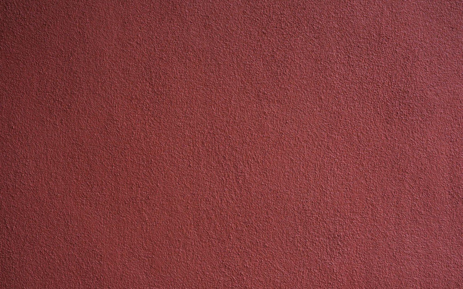 Close-up of a textured dark red plastered wall surface